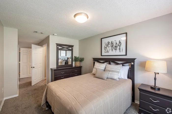 Inviting bedroom with plush bedding, elegant dark wood furniture, and soft lighting creating a cozy ambiance.