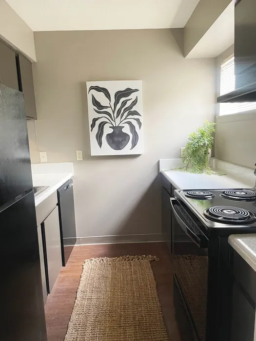 Chic and cozy kitchen featuring modern appliances, elegant wall art, and abundant natural light.