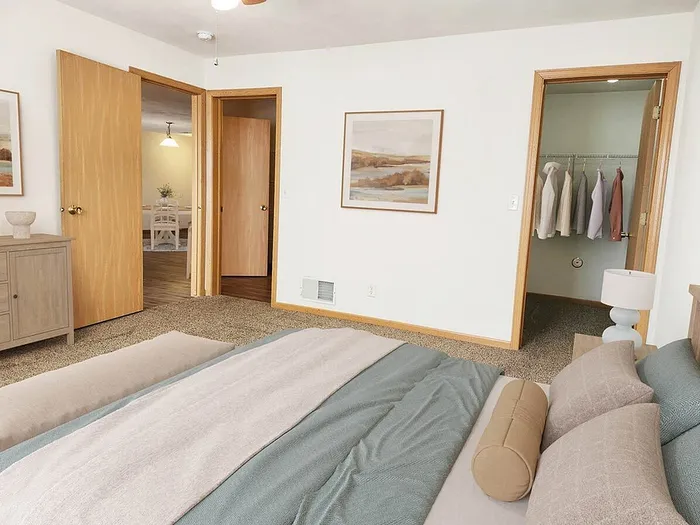 Inviting bedroom with cozy lighting, plush bedding, walk-in closet, and adjoining dining area.