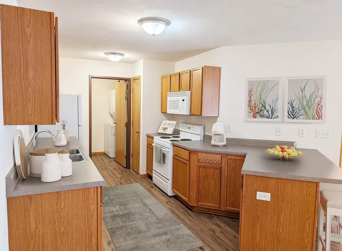 Inviting kitchen with warm wood cabinetry, modern appliances, and cozy decor for a welcoming atmosphere.