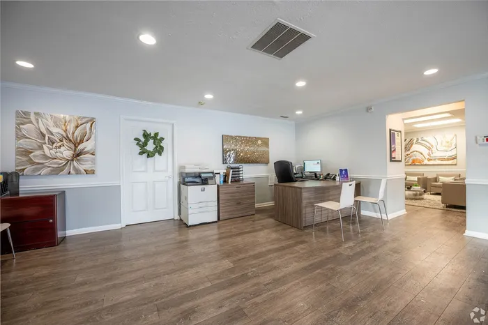 Bright and inviting office space with modern wood flooring, chic artwork, and a comfortable seating area.
