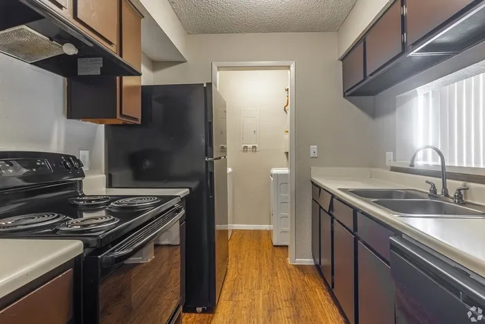 Modern kitchen with sleek countertops, dark cabinetry, and a convenient in-unit laundry area.