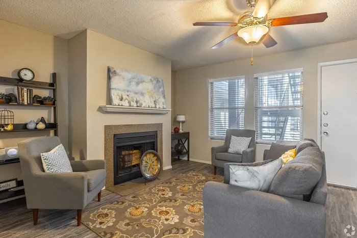 Inviting living room with a cozy fireplace, stylish decor, and abundant natural light from large windows.