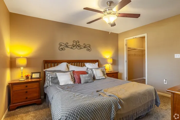 Inviting bedroom with warm lighting, elegant decor, and spacious walk-in closet for added luxury.