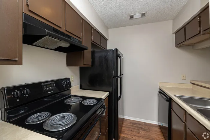 Cozy kitchen with modern appliances, dark cabinetry, and sleek countertops, ideal for culinary enthusiasts.