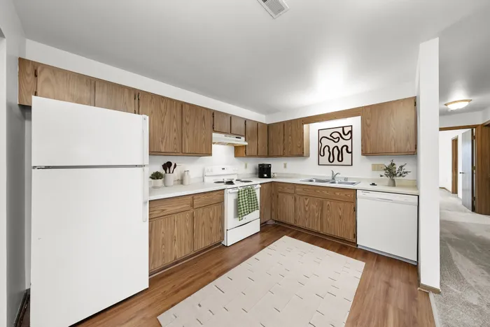 Inviting kitchen with warm wooden cabinetry, modern appliances, and elegant decor; perfect for home chefs.