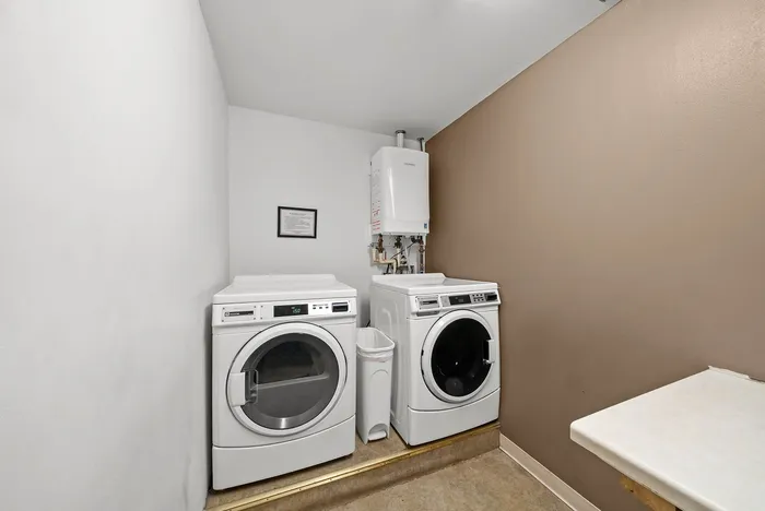Contemporary laundry room with modern washer and dryer, featuring sleek cabinetry and neutral tones for a cozy atmosphere.