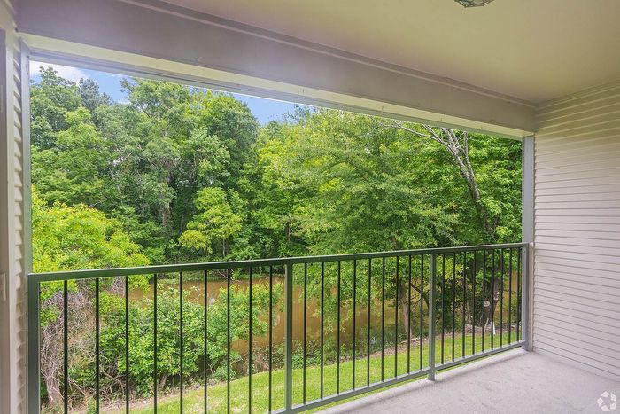 Charming apartment balcony with serene forest view, offering a tranquil and private outdoor retreat.