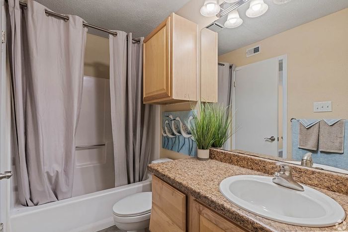 Elegant bathroom with granite countertops, stylish lighting, and a clean bathtub, perfect for a relaxing retreat.