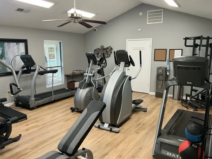 Inviting fitness center with modern exercise equipment, including treadmills and elliptical machines, set against a clean, spacious interior.