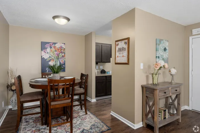 Charming dining area with elegant wooden furniture, floral artwork, and subtle decor accents creating a cozy and inviting atmosphere.
