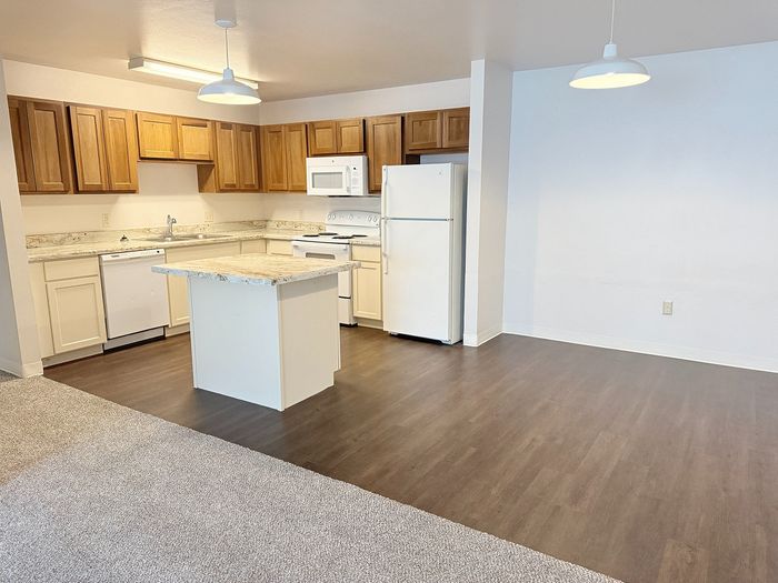 Charming open-concept kitchen and living area with modern appliances and elegant wood cabinetry.