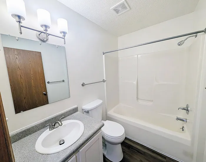 Modern bathroom featuring elegant lighting, sleek sink, and a spacious bathtub with a contemporary design.