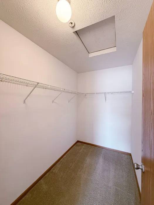 Spacious walk-in closet with ample shelving, perfect for organizing your wardrobe.