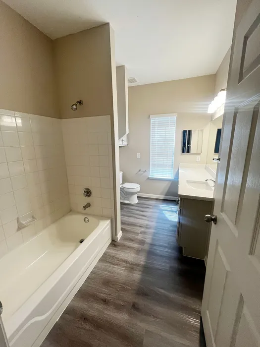 Bright, modern bathroom with elegant tiles, sleek fixtures, and natural light through large window.