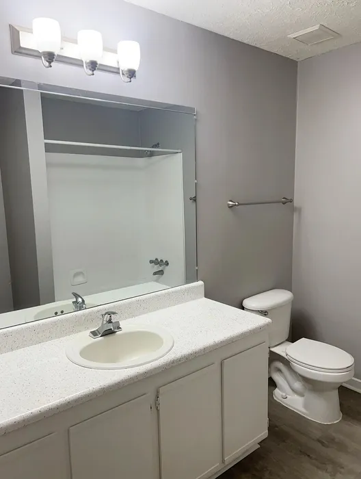 Contemporary bathroom with sleek white cabinetry, modern lighting, and a spacious vanity.