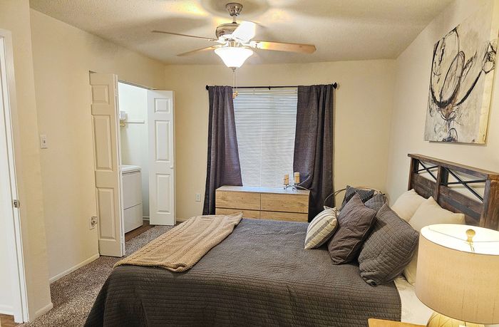 Inviting bedroom featuring elegant decor, plush bedding, and a ceiling fan for added comfort.
