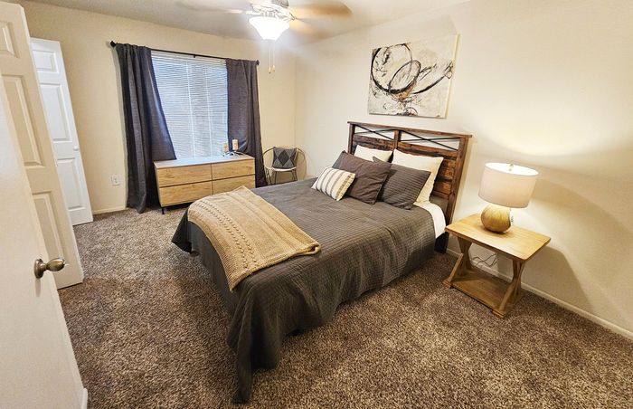 Cozy bedroom featuring a plush bed with elegant linens, warm lighting, and tasteful decor for a comfortable retreat.