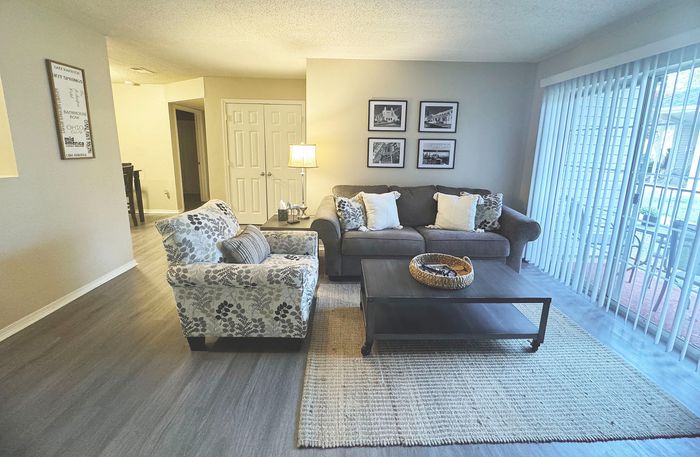 Inviting living room with stylish furniture, elegant decor, and abundant natural light through floor-to-ceiling windows.