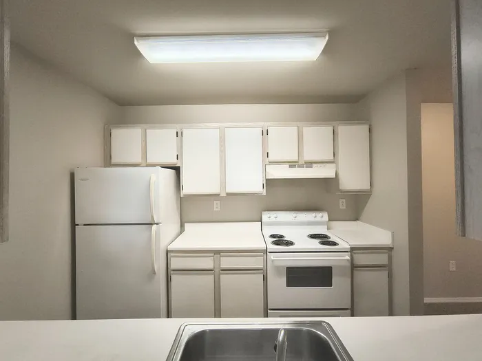 Cozy kitchen with modern white cabinetry, spacious countertops, and a sleek electric stove, perfect for culinary creations.