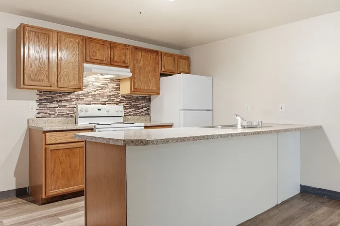 Modern kitchen with warm wood cabinetry, sleek countertops, and stylish mosaic backsplash, ideal for culinary creativity.