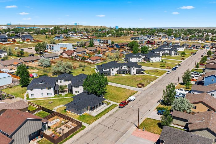Charming suburban neighborhood with spacious homes, green lawns, and picturesque streets under a clear blue sky.