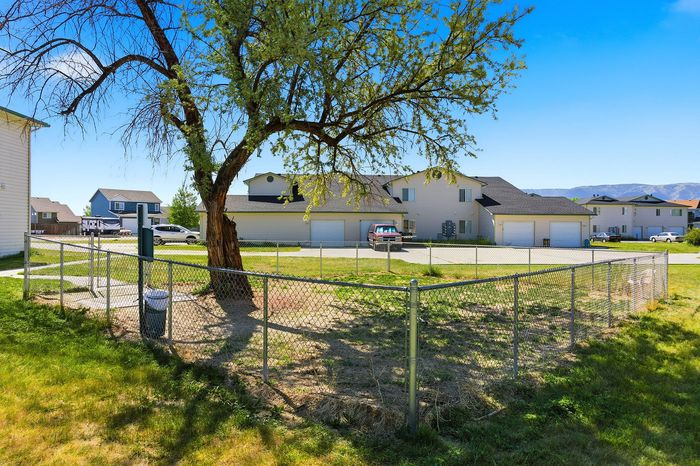 Charming suburban neighborhood with vibrant greenery and modern homes under a clear blue sky.