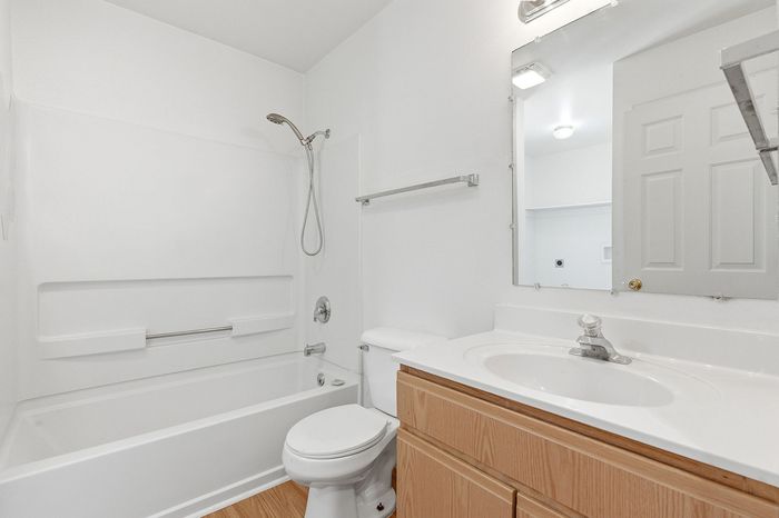 Bright and modern bathroom featuring a sleek bathtub, elegant white sink, and contemporary fixtures.