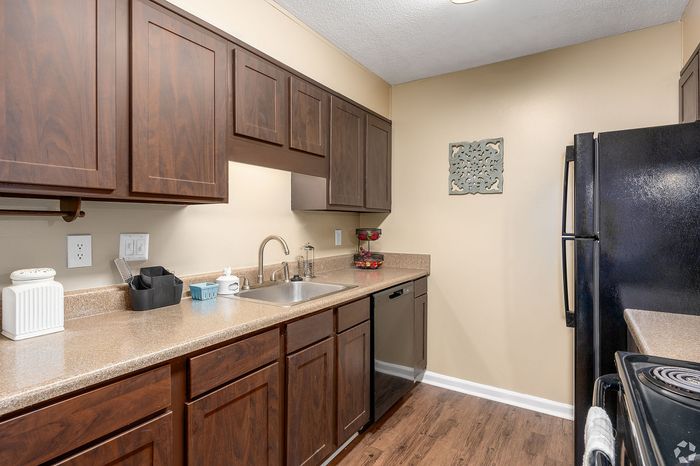 Modern kitchen with dark wood cabinetry, sleek countertops, and contemporary appliances for an inviting cooking space.