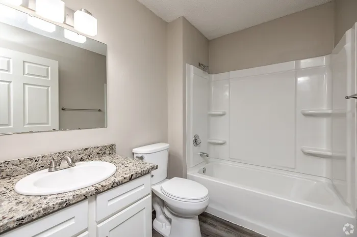 Contemporary bathroom with sleek granite countertops, modern fixtures, and a pristine bathtub for a relaxing retreat.