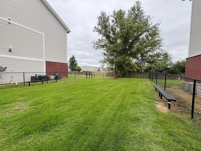 Spacious green courtyard at apartment complex with well-maintained lawn and outdoor seating, perfect for relaxation and leisure.