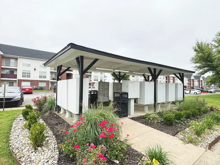 Charming modern apartment complex featuring beautifully landscaped mail area with vibrant flower beds and convenient mailboxes.