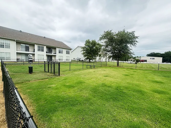 Inviting apartment complex with lush green lawns, fenced areas, and spacious balconies, perfect for outdoor enjoyment.