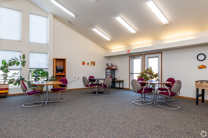 Bright and inviting communal area featuring modern decor, vibrant seating, and large windows for natural light.