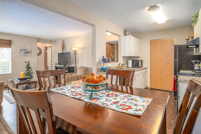 Inviting open-concept dining and kitchen area with elegant decor, blending seamlessly into a cozy living room for a warm home atmosphere.