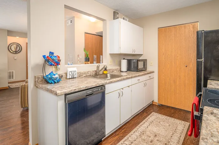 Inviting kitchen with modern appliances, sleek countertops, and warm wooden accents offering a functional culinary space.