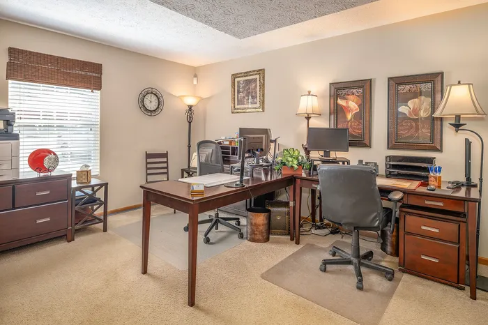Inviting home office with elegant wooden furniture, natural light, and decorative artwork, ideal for productivity and style.