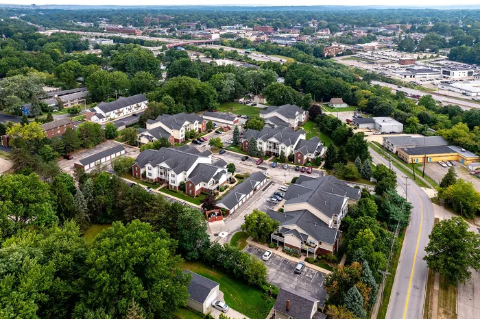 Scenic aerial view of a charming apartment complex nestled in lush greenery, offering convenient urban living with easy access to nearby amenities.