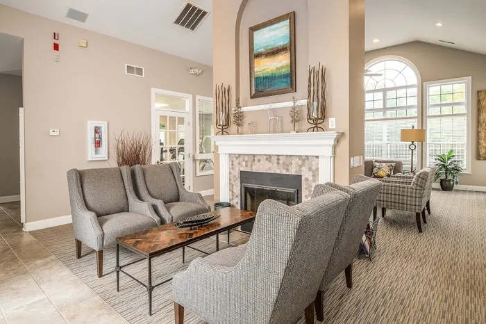 Elegant living room with plush seating, a cozy fireplace, and abundant natural light from large arched windows.