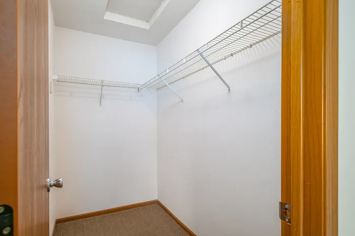 Inviting walk-in closet with ample shelving, perfect for organized storage and maximizing space.