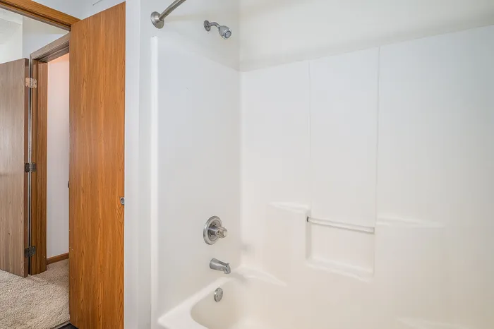 Modern bathroom with sleek white shower and stylish wood accents.