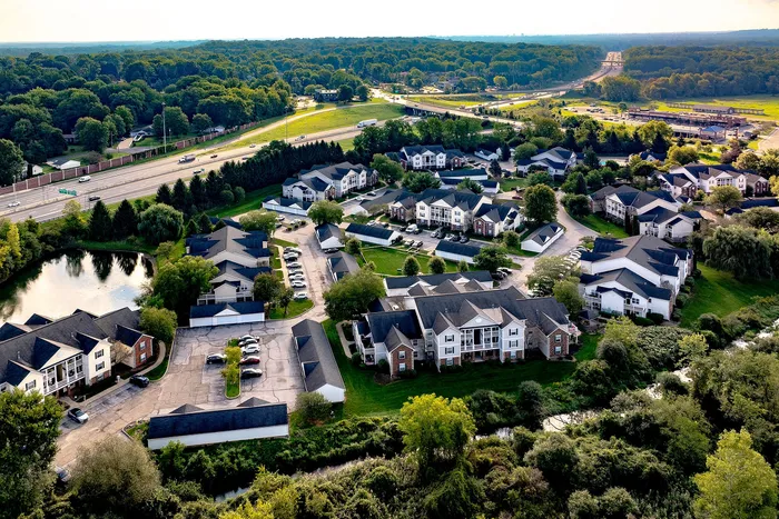 Charming aerial view of a peaceful residential community surrounded by lush greenery and scenic landscapes.