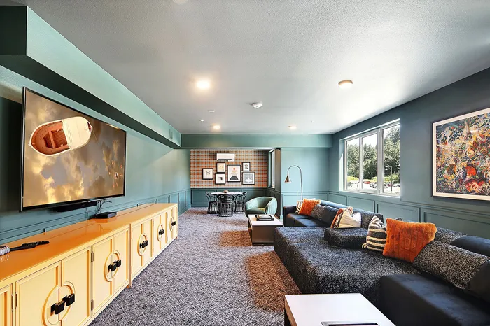 Modern apartment lounge with chic decor, plush seating, and large windows filling the space with natural light.