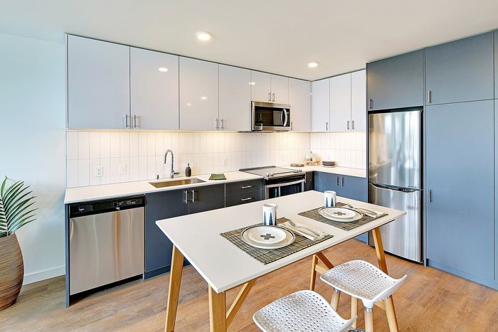 Modern kitchen featuring sleek cabinetry, stainless steel appliances, and a stylish dining area with chic decor.