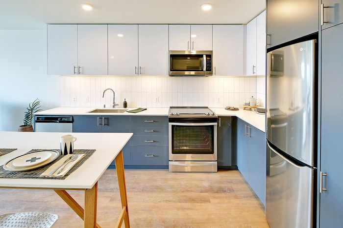 Modern kitchen with sleek cabinetry, stainless steel appliances, and elegant dining setup, perfect for culinary enthusiasts.