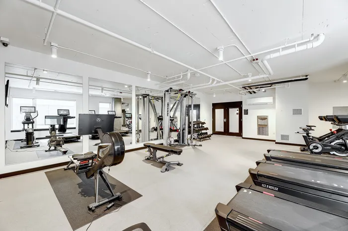 Modern fitness center equipped with high-tech treadmills, stationary bikes, and versatile strength training equipment, perfect for an invigorating workout.