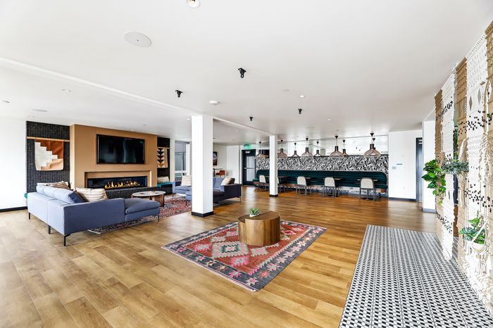 Luxurious open-concept lounge area showcasing stylish seating, modern fireplace, and chic dining space with decorative pendant lighting.