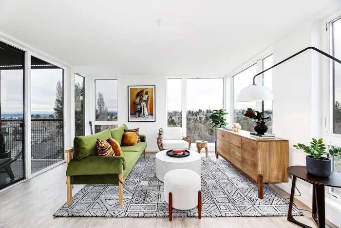 Bright and airy living room with stunning views, featuring a chic green sofa, contemporary art, and elegant modern decor. Perfect space for relaxation and entertaining.