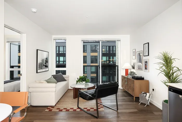 Modern living room with sleek furnishings, large windows for natural light, and chic decor creating an inviting atmosphere.