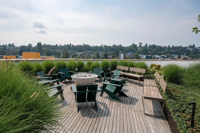 Charming rooftop patio with cozy seating and lush greenery, offering stunning cityscape views.